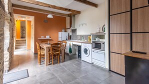 A compact kitchen with a dining area, a washing machine, and a microwave.