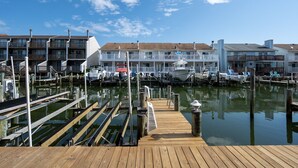 Una marina con muelles de madera, barcos y un edificio con balcones.