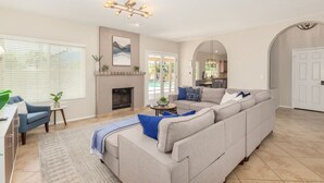 A living room with a sectional sofa, a fireplace, and a dining area. - *Great Rates Available* | North Scottsdale Peaceful Paradise (Scottsdale)