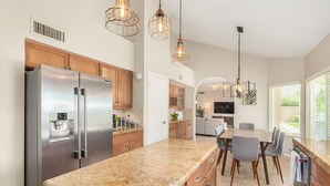 A modern kitchen with granite countertops, stainless steel appliances, wooden cabinets, and pendant lighting. - *Great Rates Available* | North Scottsdale Peaceful Paradise (Scottsdale)