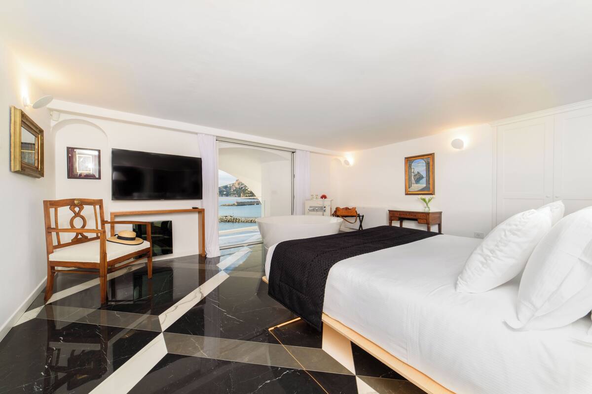 Une chambre d’hôtel avec un lit, une télévision, un bureau et une chaise.
