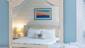 A hotel room with a bed, a nightstand, a lamp, a framed picture, and a mirror.