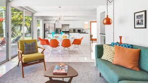 Een moderne woonkamer met een bank, fauteuil en eettafel.