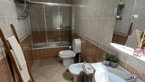 A bathroom with a shower, toilet, bidet, and sink. - Qta.da Flor - Fantastic Apartment With Pool (Albufeira)