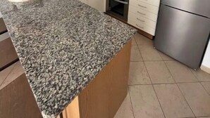 A compact kitchen with granite countertops, stainless steel appliances, and white cabinetry. - Qta.da Flor - Fantastic Apartment With Pool (Albufeira)