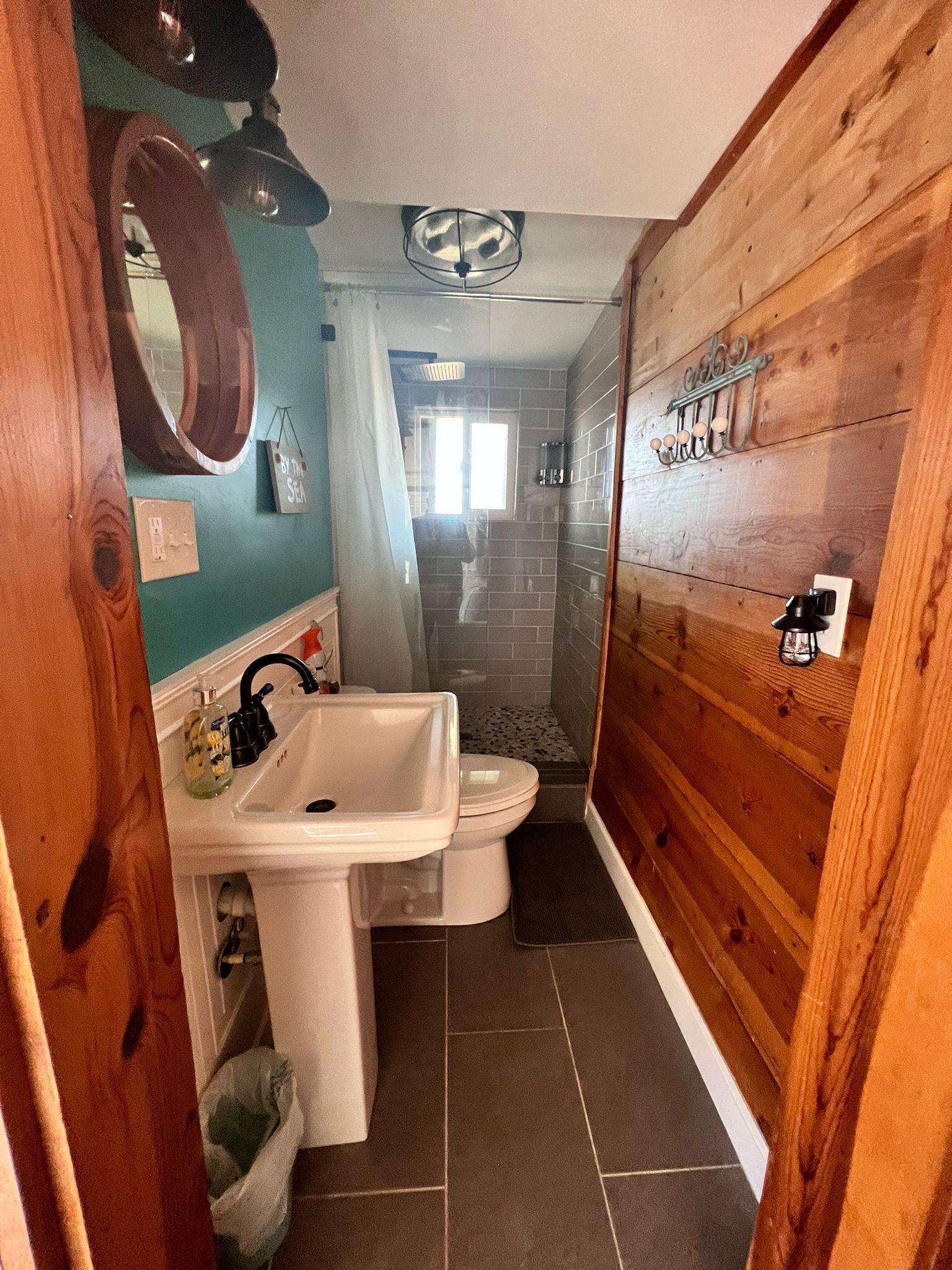 A compact bathroom with a sink, toilet, and shower.