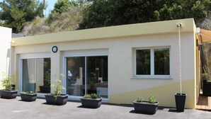 Un edificio moderno con tetto piatto, ampie finestre e piante in vaso.