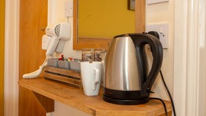 A wooden counter with a white telephone, a white mug, and a stainless steel kettle. - The Star Inn (Stroud)