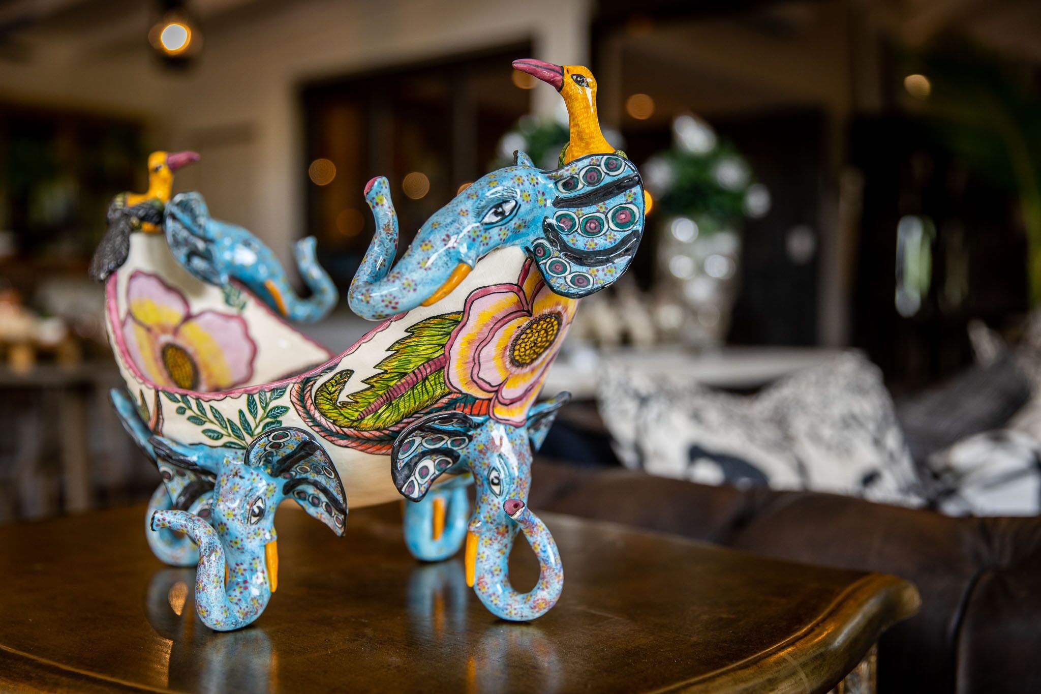 Una escultura de cerámica decorativa de un elefante sobre una mesa.