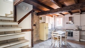 Una cocina con una mesa de comedor, un refrigerador y una estufa.