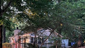 A house with a front porch, surrounded by trees and a sloped lawn. - Azalea Cottage 1Br/1Ba with spacious Deck overlooking LKN and 2 Private docks.   (Mooresville)