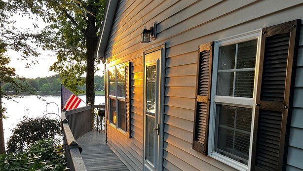 A waterfront house with a wooden deck, a covered porch, and a view of the lake. - Azalea Cottage 1Br/1Ba with spacious Deck overlooking LKN and 2 Private docks.   (Mooresville)