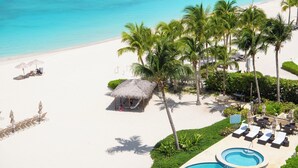 A resort with a pool, lounge chairs, and a beach.
