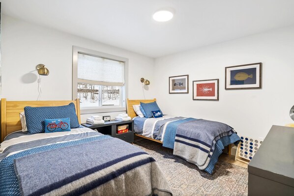 Une chambre d’hôtel avec deux lits, une fenêtre et des œuvres d’art murales.