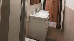 Un baño pequeño con inodoro, bidé, lavabo y armarios de madera.