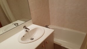 Ein Badezimmer mit Waschbecken, Spiegel und Badewanne.