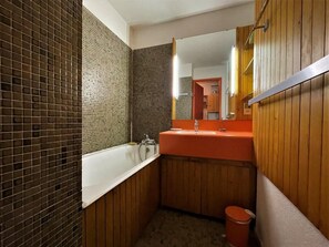 A compact bathroom with a bathtub, a sink, and a mirror. - 10m from ski slopes, 3rd floor, balcony, tv, 24m², Les Menuires (Les Menuires)