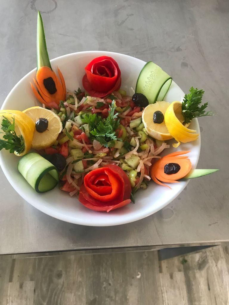 A bowl of salad with various vegetables and garnishes.