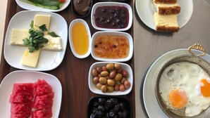 Ein Tablett mit verschiedenen Speisen, darunter Käse, Eier und Gemüse.