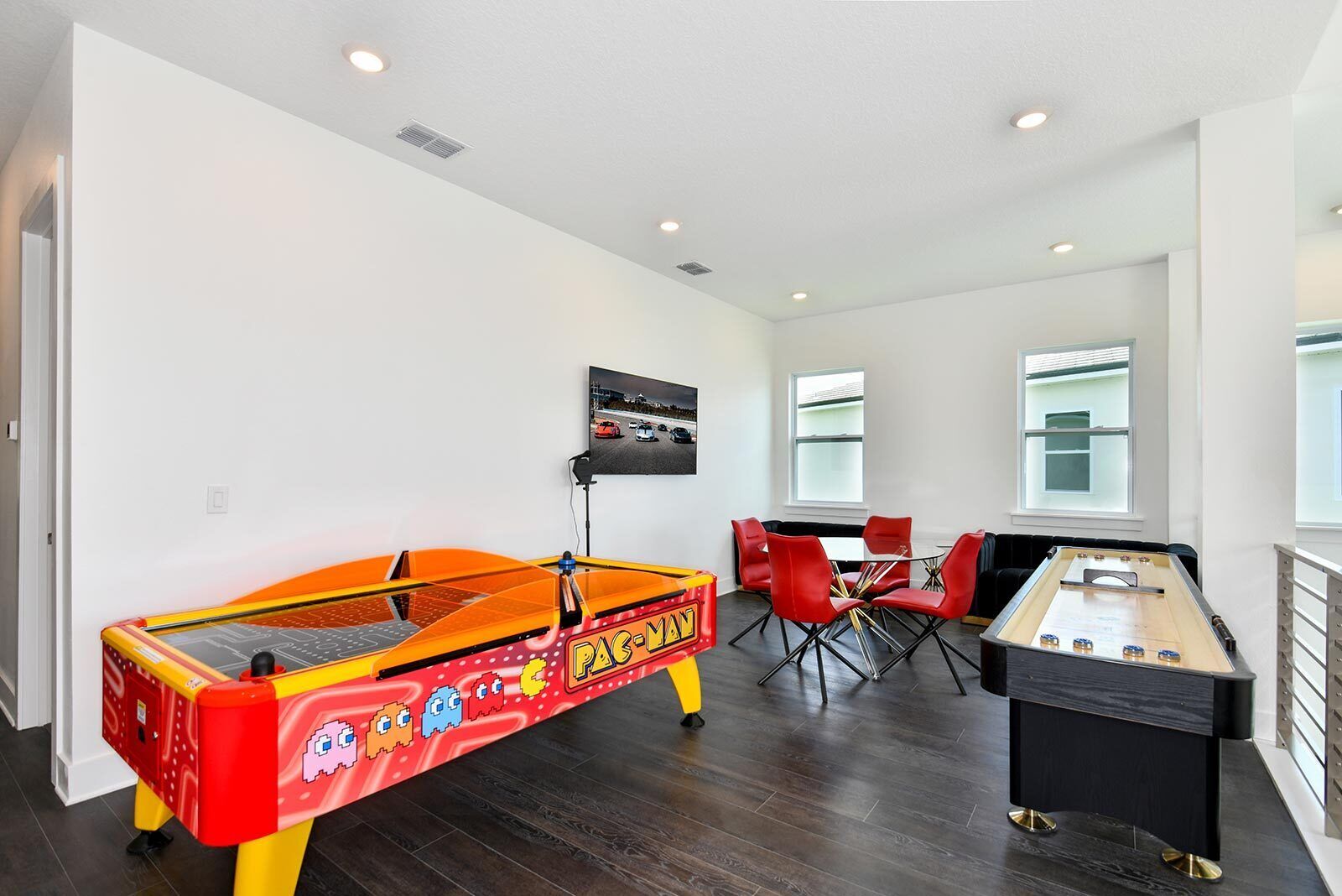 Een kamer met een tafelvoetbaltafel, een Pac-Man-arcadekast en een tafeltennistafel.