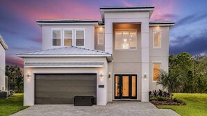 Une maison moderne à deux étages, dotée d’un garage, de grandes fenêtres et d’une pelouse bien entretenue.