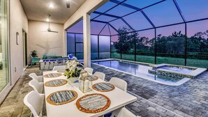 Une terrasse extérieure couverte avec une piscine, un coin repas et des sièges.
