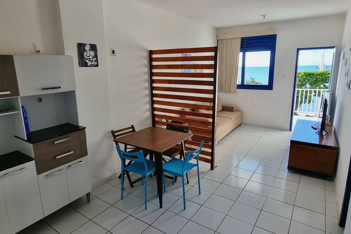 Un espace de vie compact comprenant une kitchenette, un coin repas et un balcon avec vue.