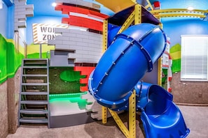 Zona de juegos infantiles con tobogán, escalera y un letrero que dice 'WON'T ZONE'.