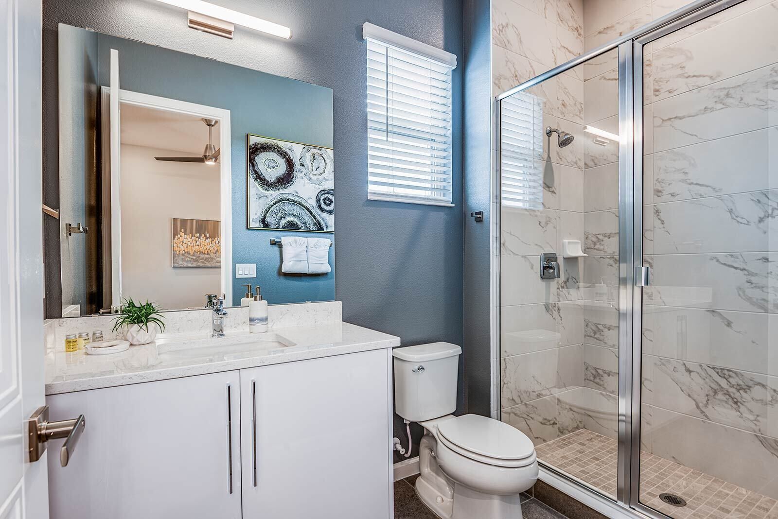 Een moderne badkamer met douche, toilet en wastafel.