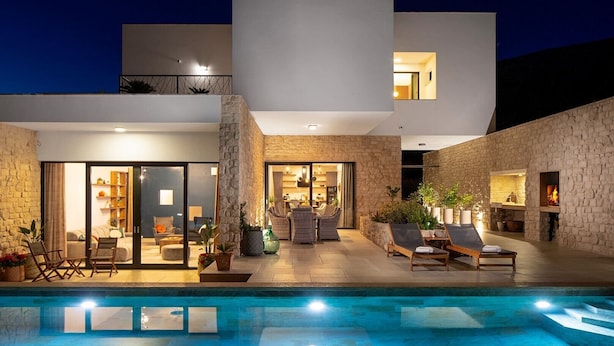 A modern house with a swimming pool, stone walls, and a cozy interior with seating and a fireplace. - Luxury Villa Praska with 3 en-suite bedrooms, Finnish Sauna, private pool (Podstrana)