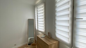 Un dormitorio con un aparador de madera, un espejo y una mesita de noche.