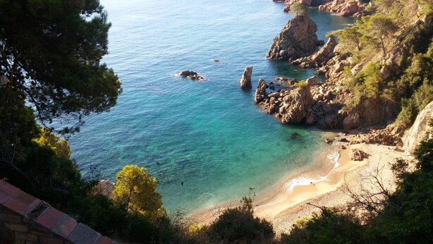 A coastal landscape with clear turquoise waters, rocky cliffs, and a sandy beach. - Apartamento con Encanto al Lado de la Playa El Golfet (Calella de Palafrugell)