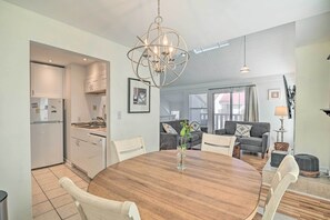Enjoy meals around the round dining table, surrounded by comfortable chairs and a stylish chandelier.