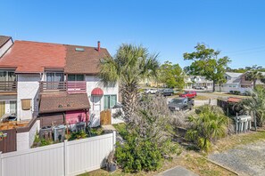 A residential area with houses, a fenced yard, and parked cars. - Myrtle Beach Condo: Balconies, Walk to Beach! (Myrtle Beach)