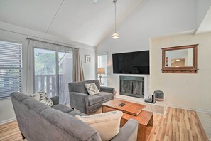 Relax in this stylish living room with a high ceiling, large windows, and a comfortable sofa set.