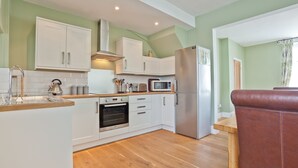 Eine moderne Küche mit weißen Schränken, Edelstahlgeräten und einer Holz Arbeitsplatte.