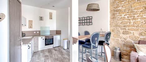 A modern kitchen with a dining area, stone wall, and a cozy seating area.