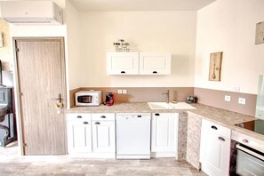 A compact kitchen with white cabinets, a microwave, a coffee maker, and a dishwasher. - ⚘ Superb luxury T2 ⚘ for 4 people (Montignac)