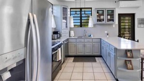 Une cuisine moderne équipée d’un réfrigérateur, d’une cuisinière, d’un évier et de placards.