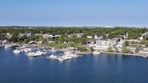 A marina with several boats docked, surrounded by residential buildings and greenery. - First-Floor Lakefront Gem | Downtown Charlevoix | Pool, Hot Tub, Sauna (Charlevoix)