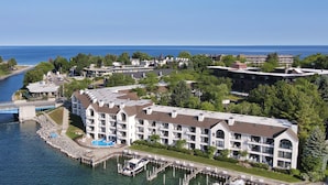 A waterfront hotel with multiple buildings, a marina, and a bridge. - First-Floor Lakefront Gem | Downtown Charlevoix | Pool, Hot Tub, Sauna (Charlevoix)