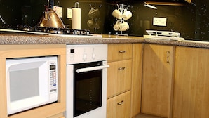 A compact kitchen with a microwave, oven, and stove. - Linden Apartment -  an apartment that sleeps 4 guests  in 2 bedrooms (Stirling)