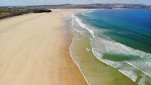 A wide sandy beach with gentle waves and a clear view of the ocean. - Luxury Tent-Peaceful Meadow-Firepit-Superb Views.Dogs WiFi-Beaches 10 mins SAUNA (Truro)