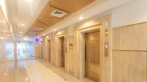 A clean, modern hallway with elevators and a polished floor.
