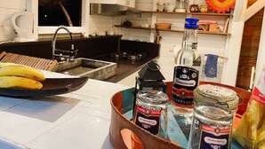 A kitchen with a wooden counter, a sink, and various food items including bananas and jars. - Charming bungalow for 2 with private Jacuzzi (Saint-François)