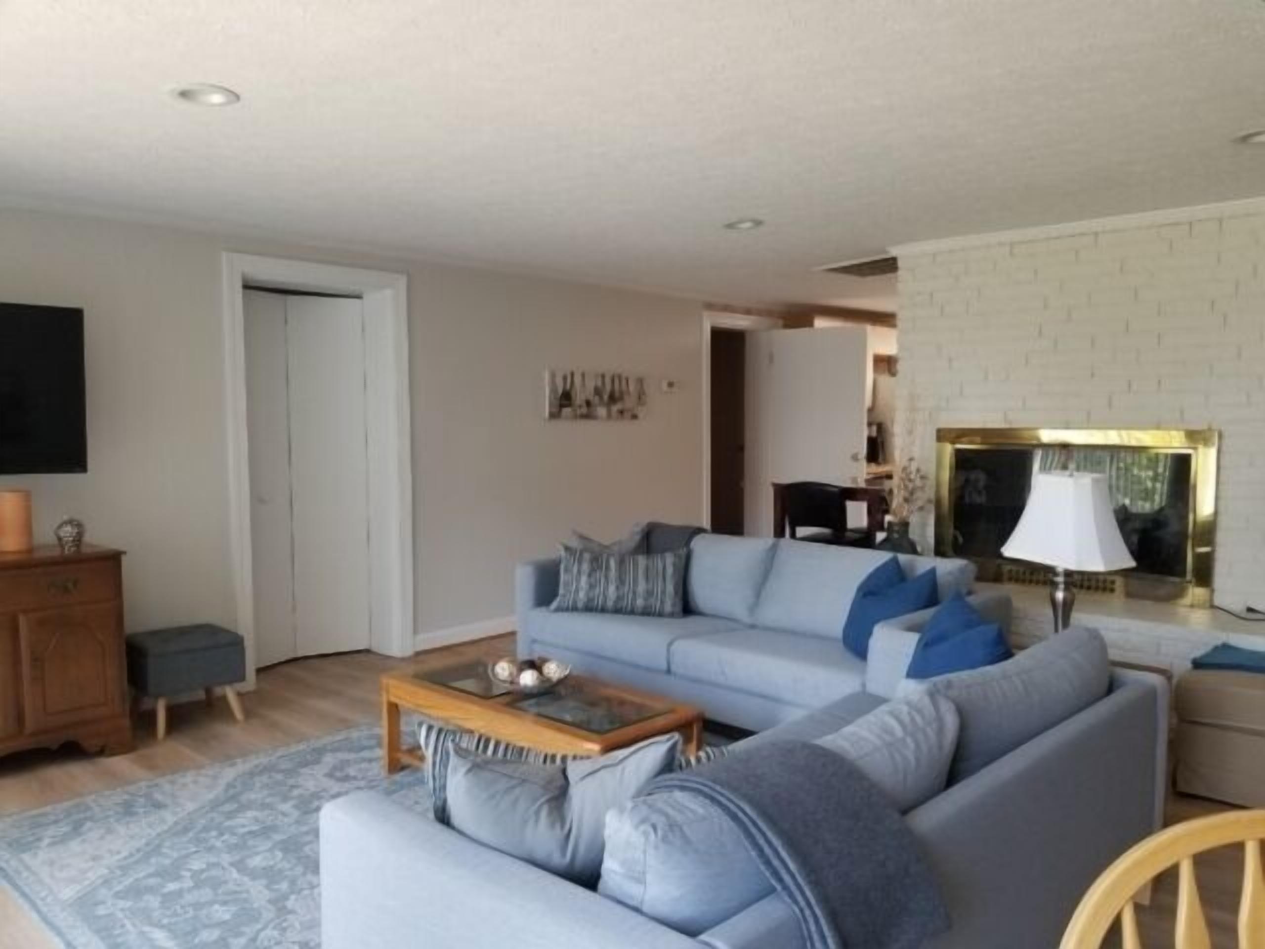 Uma sala de estar com sofá, mesa de centro e lareira.
