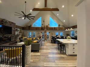 Een ruime keuken met een hoge plafond, houten balken en een groot eiland.