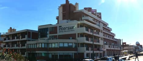 A multi-story hotel with a prominent sign for 'Intersur Hotel Village'.