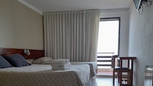 A hotel room with two beds, a desk, and a large window. - Intersur Villa Gesell (Villa Gesell)