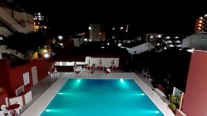 A rectangular swimming pool with a tiled deck and lounge chairs around it. - Intersur Villa Gesell (Villa Gesell)
